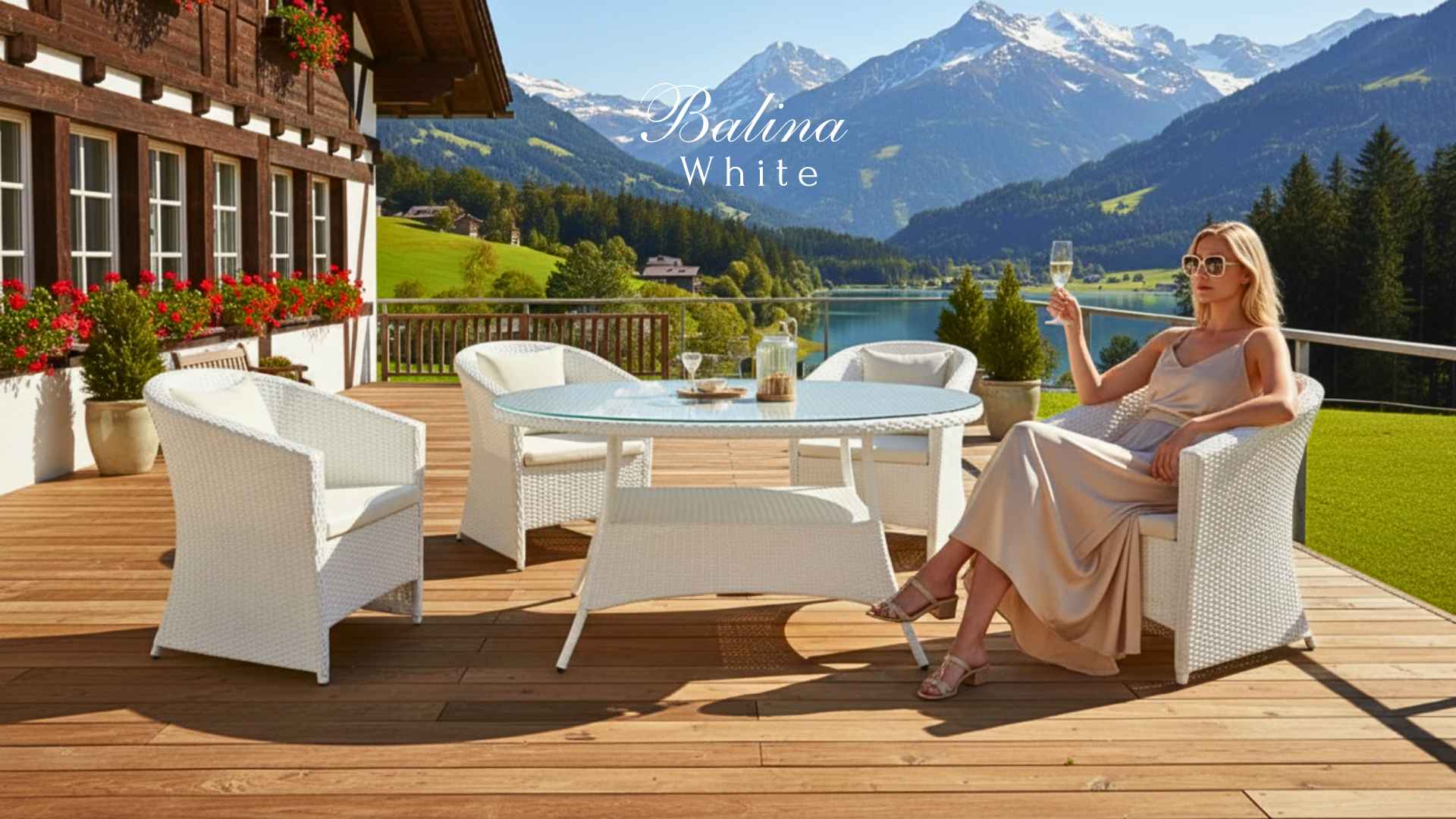Ratanový stůl BALINA Terico, bílý, se židlemi na terase s výhledem na jezero a hory, zahradní nábytek z umělého ratanu se skleněnou deskou.