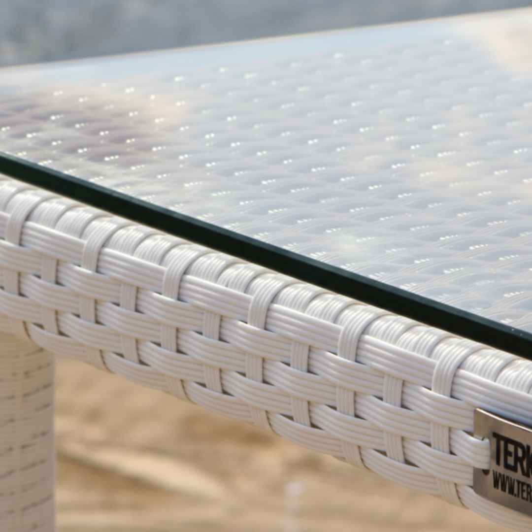 Detail desky z tvrzeného skla a bílého ratanového výpletu stolu BALINA Terico